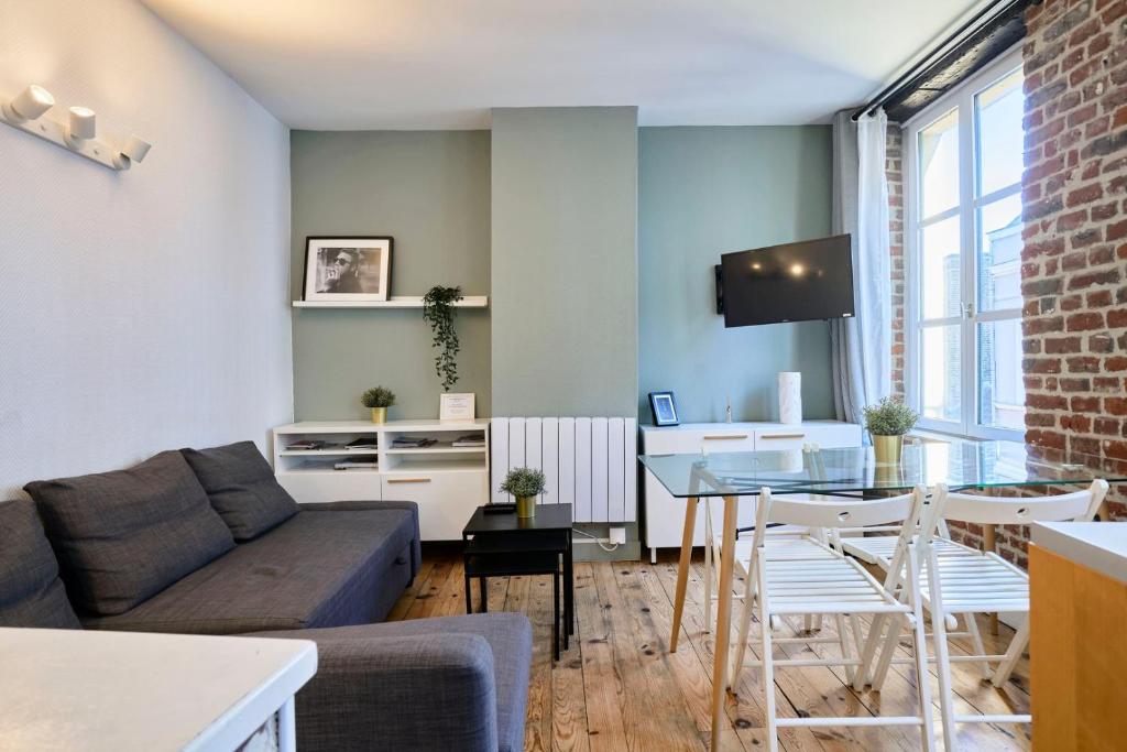 un salon avec un canapé et une table dans l'établissement Grand-place & Vieux-Lille: Equipped duplex, à Lille