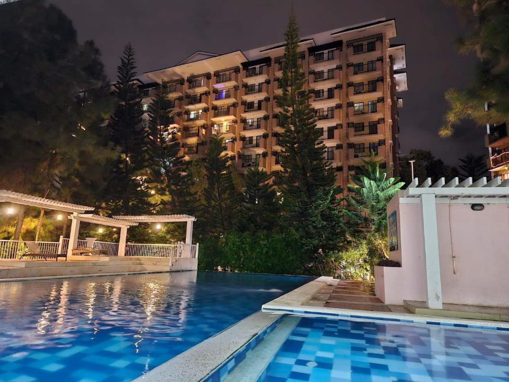 a hotel with a swimming pool in front of a building at Camella Northpoint Bajada Near Sm lanang 2bedroom unit with balcony Davao in Davao City