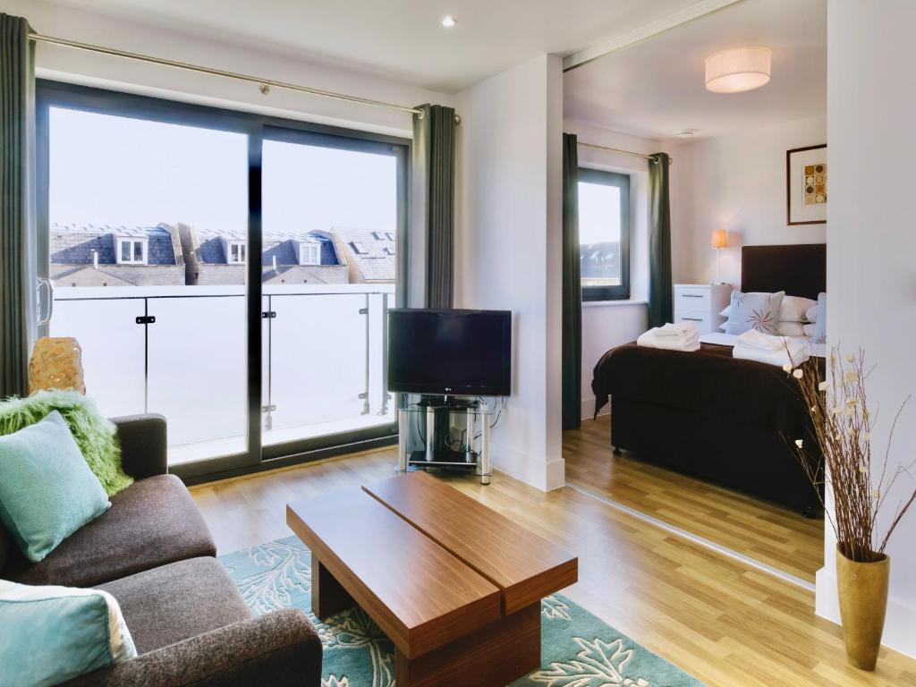 ein Wohnzimmer mit einem Sofa und einem TV in der Unterkunft Your Space Apartments - Eden House in Cambridge