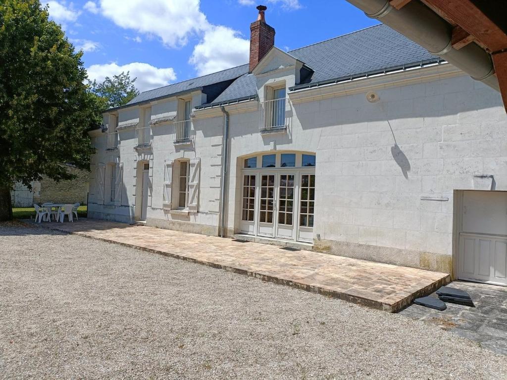 een wit bakstenen huis met een bank ervoor bij La Belle de la Gaieté in Loches