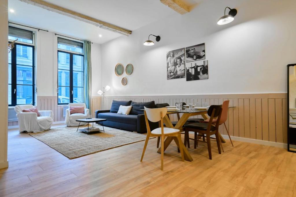 un salon avec une table et un canapé bleu dans l'établissement Old Lille: charming renovated apartment, à Lille