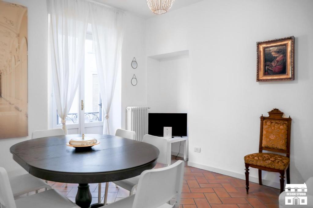 uma sala de jantar com uma mesa de madeira e cadeiras brancas em TORRETTA 4 by Design Studio em Bellano