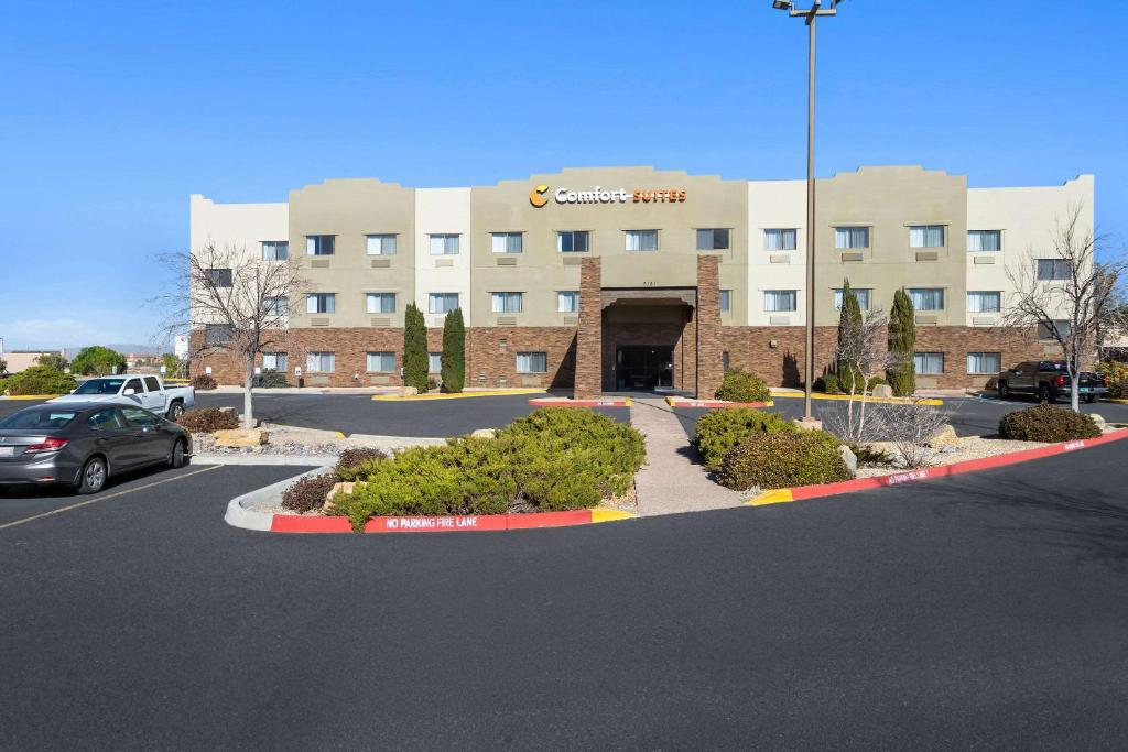 a building with a car parked in a parking lot at Comfort Suites University Las Cruces in Las Cruces