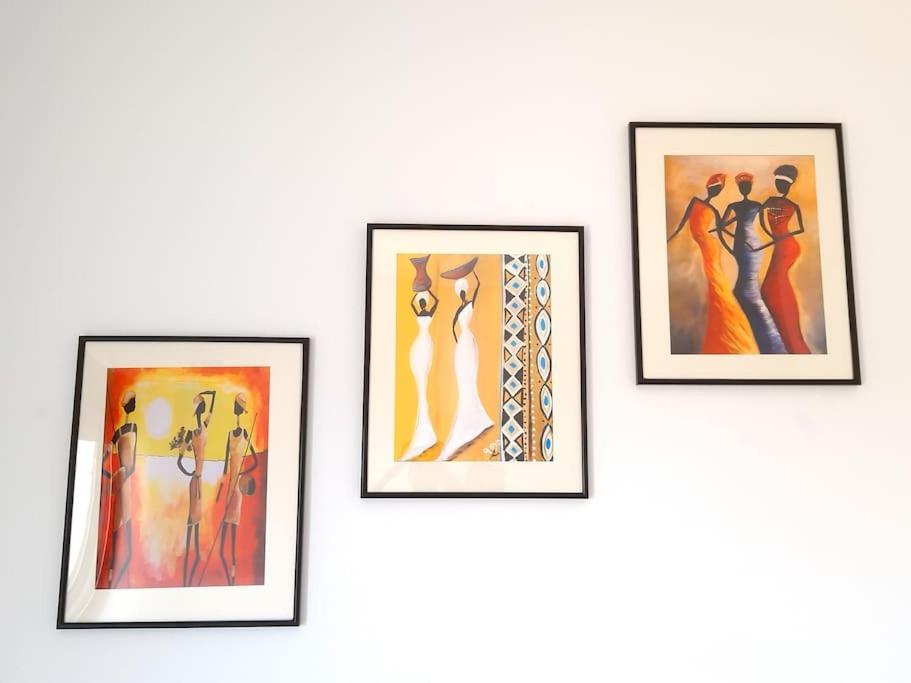 four framed pictures of women on a wall at 3 bdr spacious apt in praia in Praia