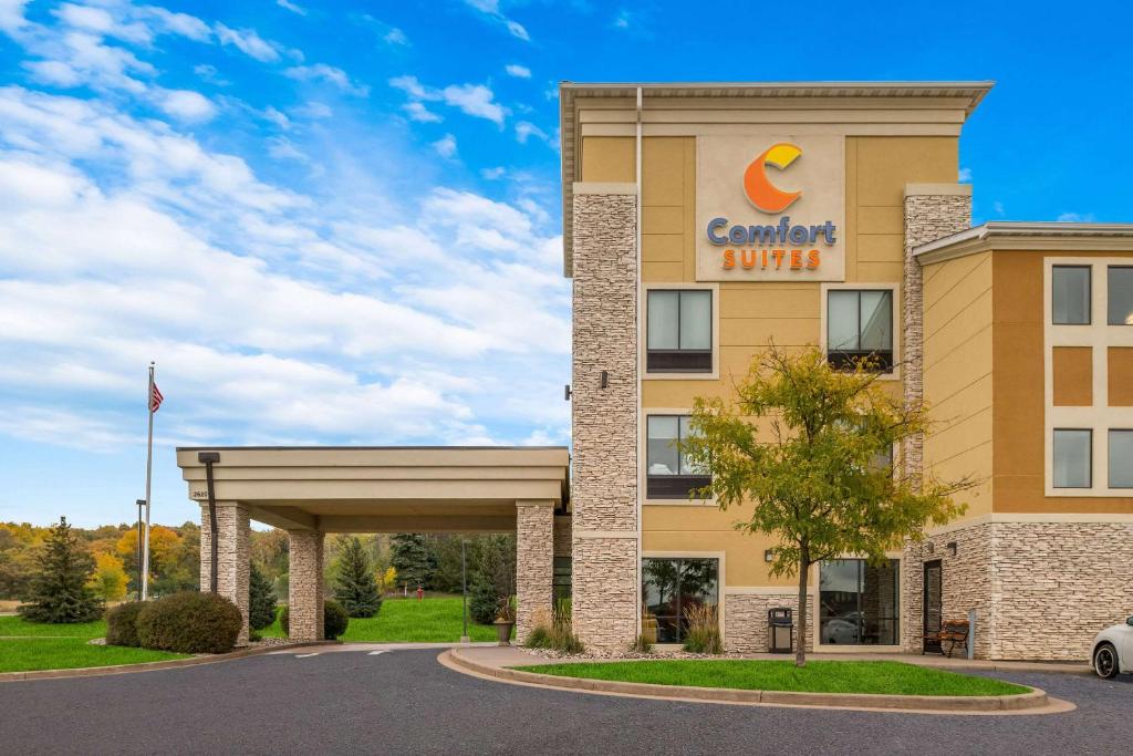 Comfort Suites Hudson I-94 في هدسون: مبنى الفندق مع وجود لافته لفندق الباحه