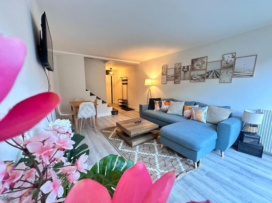 Una sala de estar con un sofá azul y una mesa. en Drouet d'Erlon duplex spacieux, terrasse au centre, en Reims
