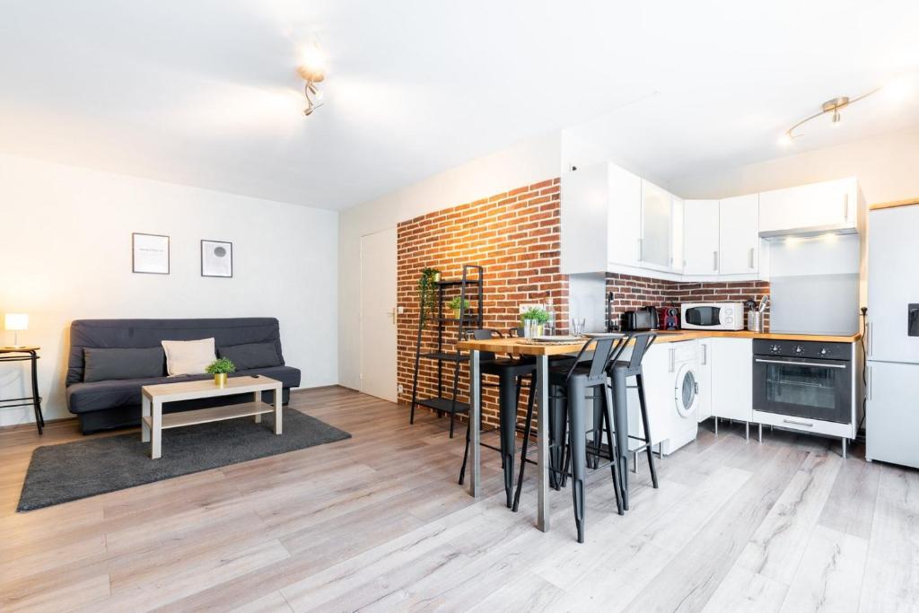 een keuken en een woonkamer met een bank en een tafel bij Fully-equipped apartment near the center of Lille in Lille