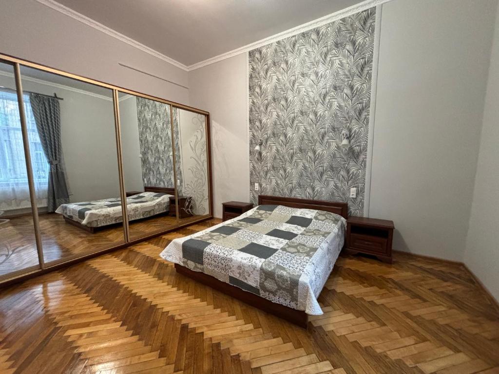 ein Schlafzimmer mit einem Bett und einem großen Spiegel in der Unterkunft Айстра in Lwiw