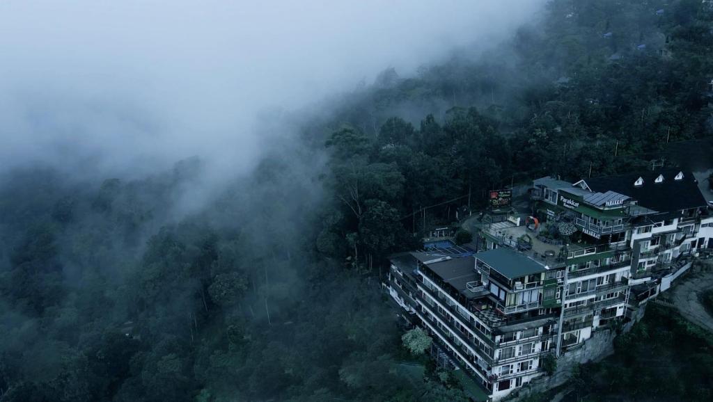 an aerial view of a city in the fog at Parakkat Nature Resort in Munnar