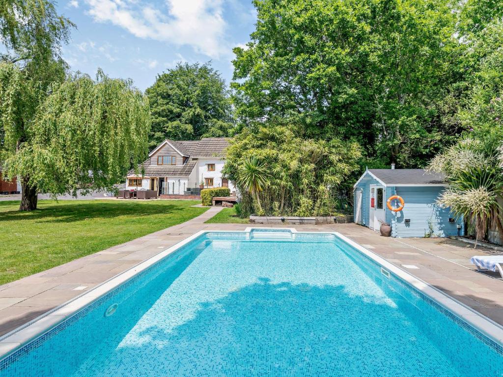 a swimming pool in a yard with a house at 5 Bed in Bransgore 91304 in Bransgore