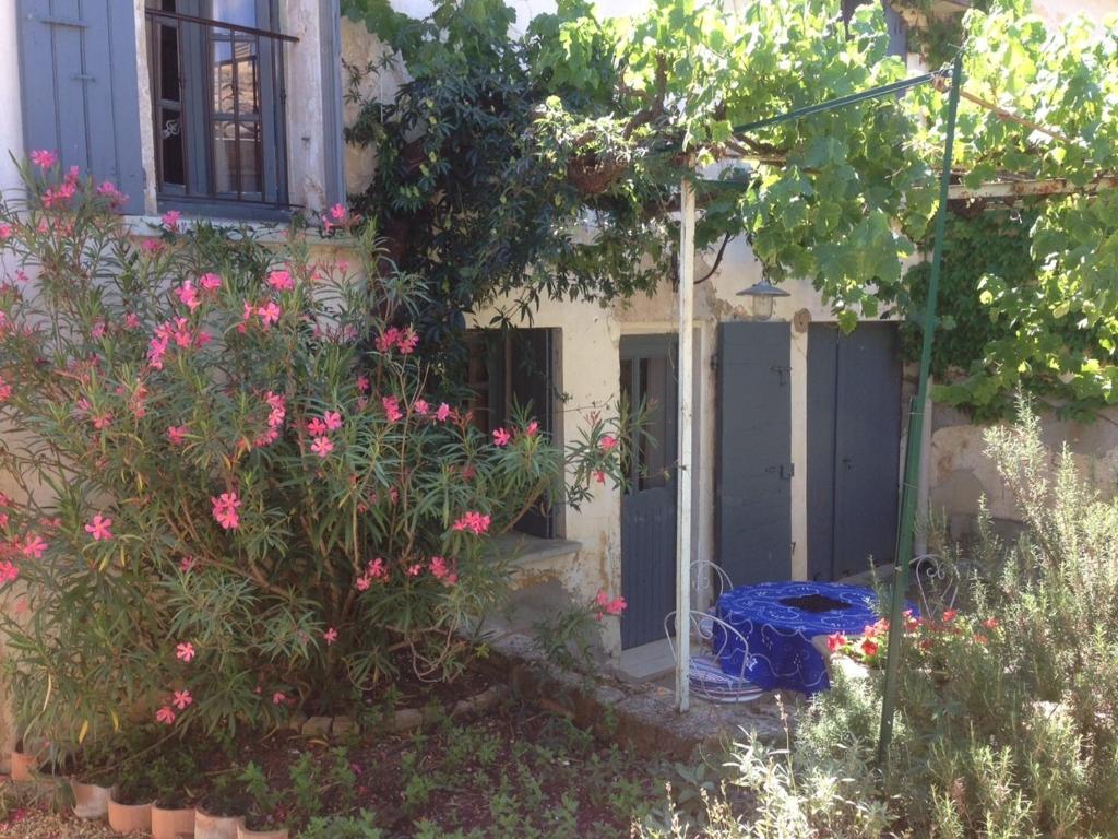 einen Garten mit rosa Blumen und einem Haus in der Unterkunft Les Gites de Catherine in Gargas