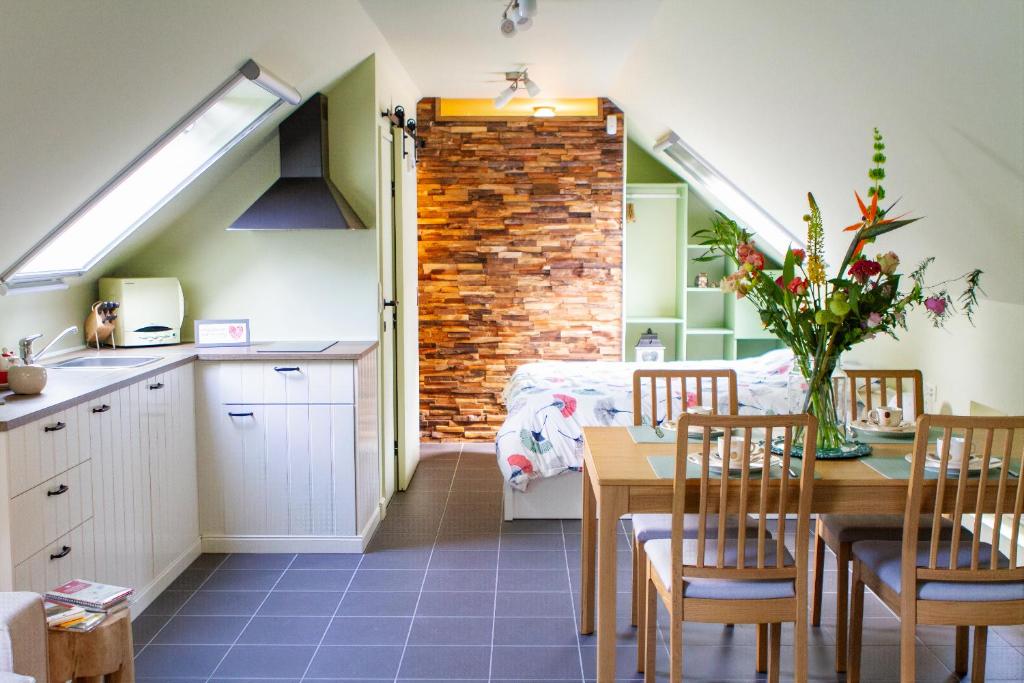 cocina y comedor con mesa y sillas en Hoeve Hulsbeek: genieten van de natuur en de rust en Geetbets