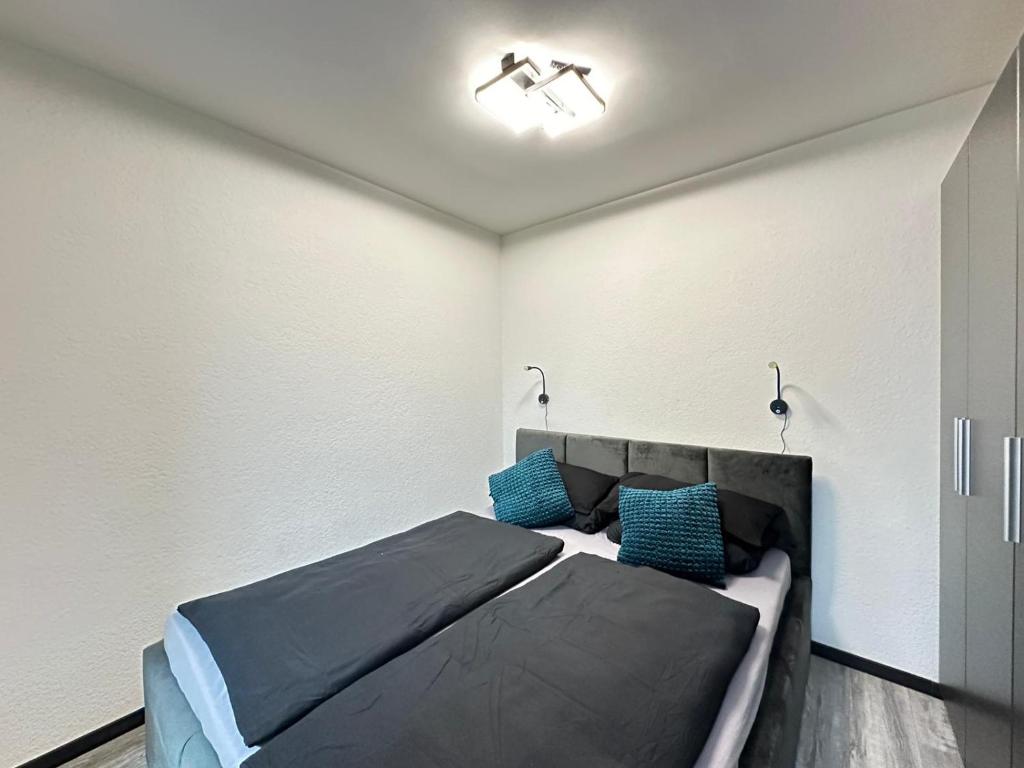 een slaapkamer met een bed en twee blauwe kussens bij Sam Apartments in Muhlheim am Main