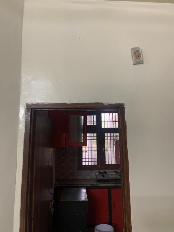 a room with a kitchen with a window and a table at 164 N Ashiyana in Lucknow