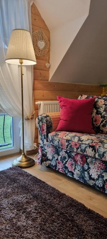 sypialnia z kanapą, lampą i poduszką w obiekcie Apartament U Moniki w Szaflarach