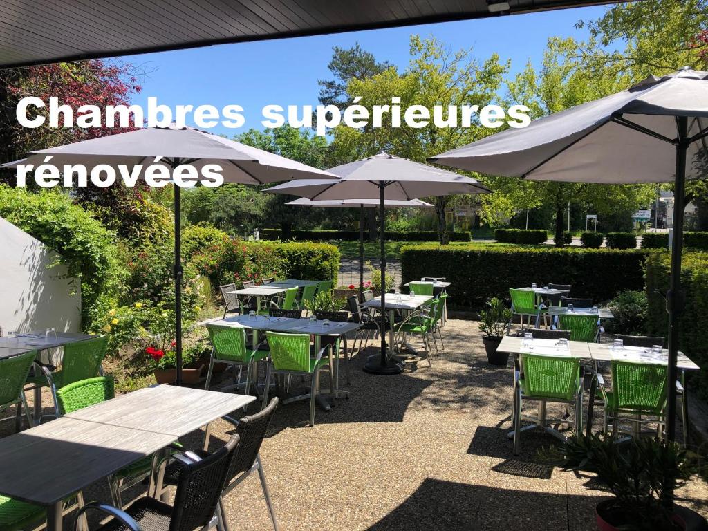 un restaurant avec des tables, des chaises et des parasols dans l'établissement Campanile Mulhouse - Illzach Ile Napoléon, à Illzach