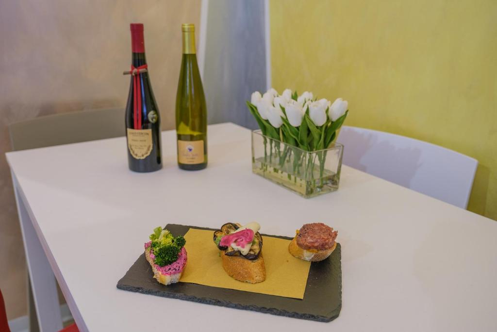 uma mesa com um prato de comida e uma garrafa de vinho em Ca' Spritz - Home em Veneza