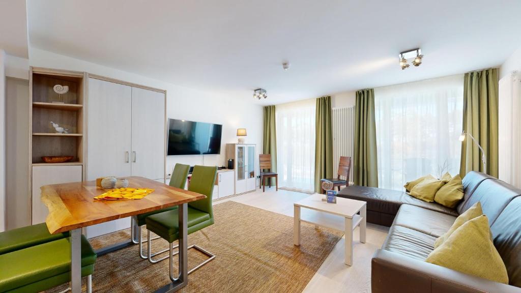 uma sala de estar com um sofá e uma mesa em FeWo in direkter Strandlage mit Balkon und Meerblick, Dünenresidenz Prora-App 111 em Binz