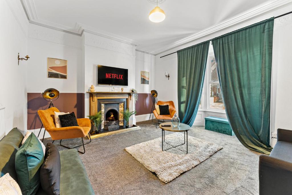 a living room with a couch and a fireplace at Lovely Central Loughborough Abode - Games Room in Loughborough