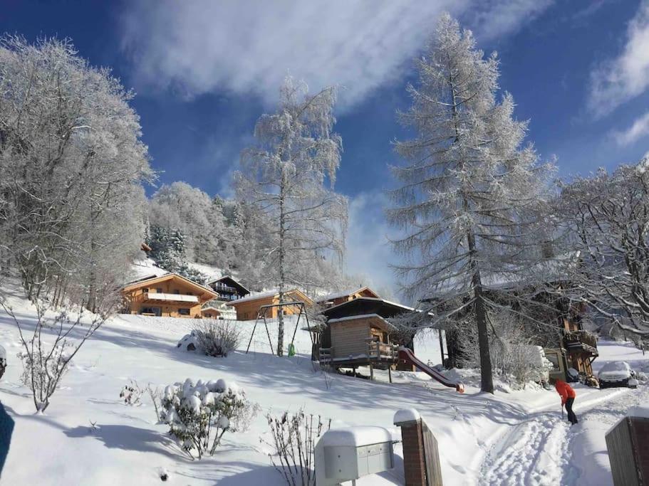 una persona caminando en la nieve frente a una cabaña en Un séjour plein de charme aux Posses!, en Gryon