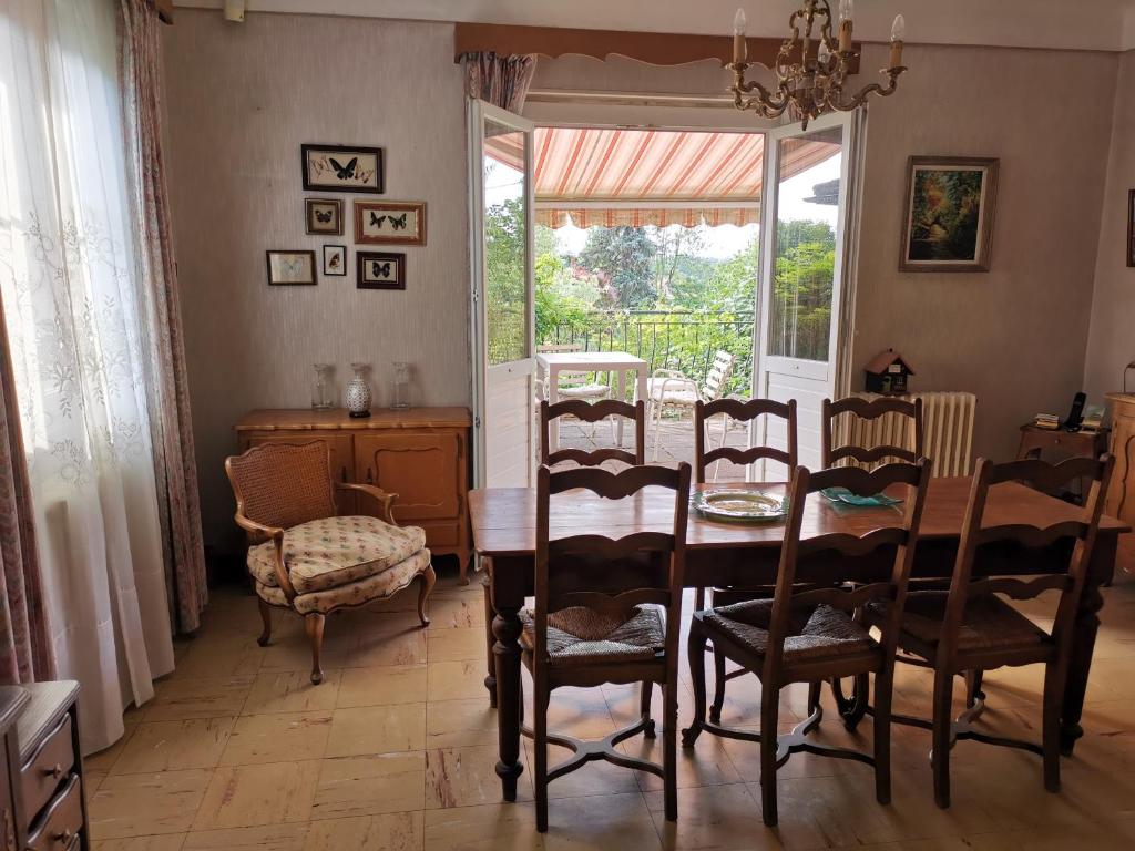 comedor con mesa, sillas y ventana en Villa Meurice, en Étrembières