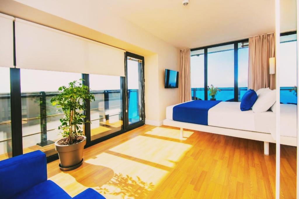 ORBI CiTY-sea view aparthotel في باتومي: غرفة نوم بسرير ونافذة كبيرة