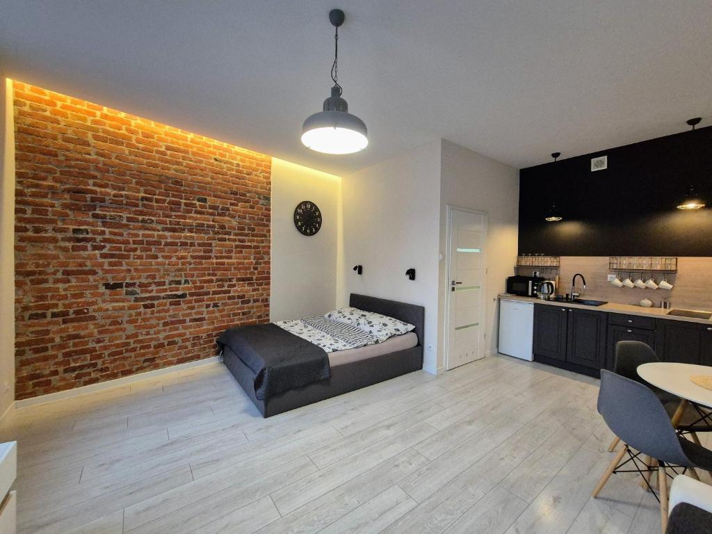 a bedroom with a bed and a brick wall at Charming Apartment in The City Centre, Łódź in Łódź