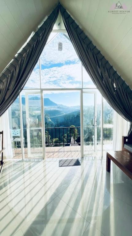 a room with a large window with a view of the mountains at Almost Heaven in Talawakele