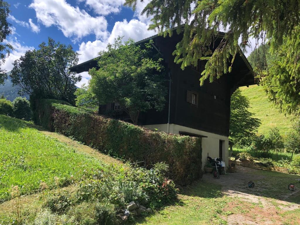 uma casa a preto e branco com uma sebe em Chalet Mex em Saint-Maurice