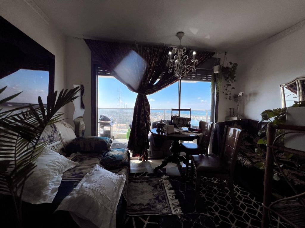 Pokój z łóżkiem, stołem i oknem w obiekcie Ashkelon-apart-hotel-boho style-standard deluxe w mieście Aszkelon