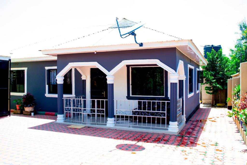 a small blue and white house with a driveway at Stay in Bomang'ombe with Breakfast in Moshi