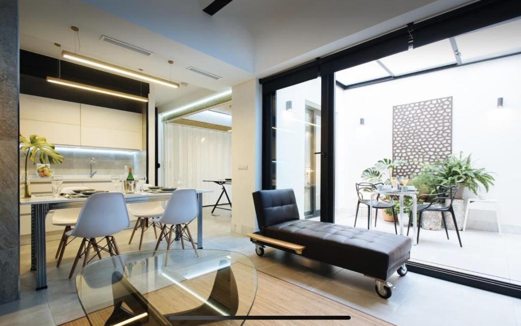a living room with a couch and a table at Lujoso loft con piscina y espacio office in Seville
