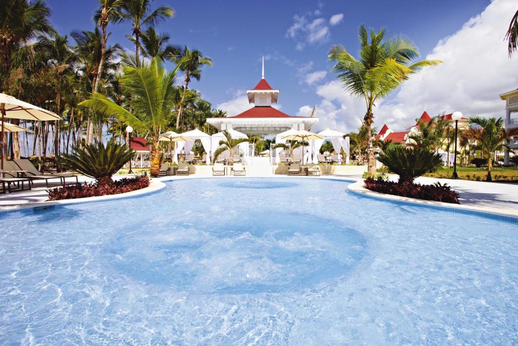 a large swimming pool in a resort with palm trees at Bahia Principe Luxury Bouganville - Adults Only All Inclusive in La Romana