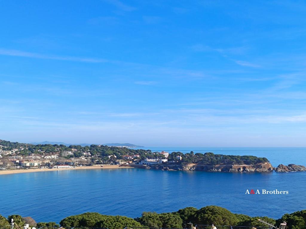 a beach in the middle of the water with houses at A&A Brothers S'Agaró in S'agaro