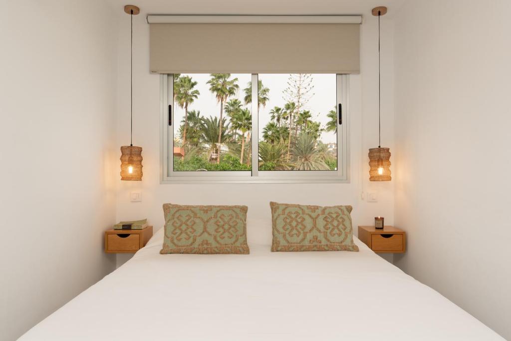 Un dormitorio con una cama blanca y una ventana. en Mangata Gran Canaria - Adults Only, en San Agustín