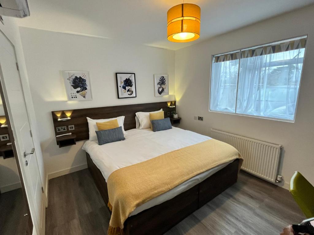 Un dormitorio con una cama grande y una ventana en Pinewood Guest House, en Iver