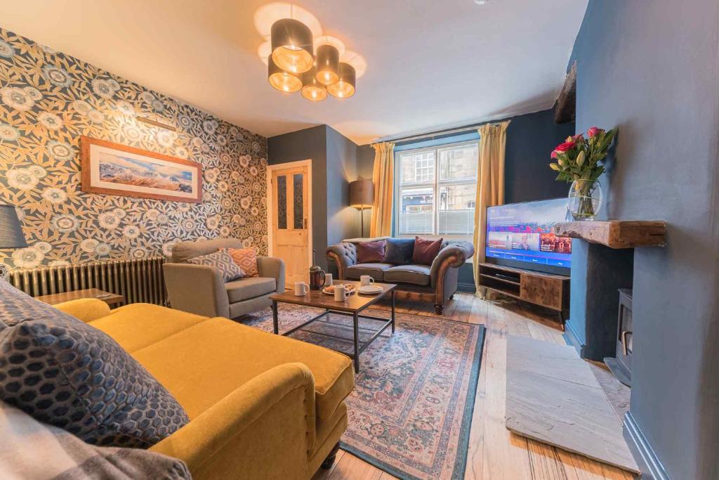 a living room with a couch and a tv at Tastefully decorated, family friendly property, central Kirkby Lonsdale, parking and EV charger in Kirkby Lonsdale