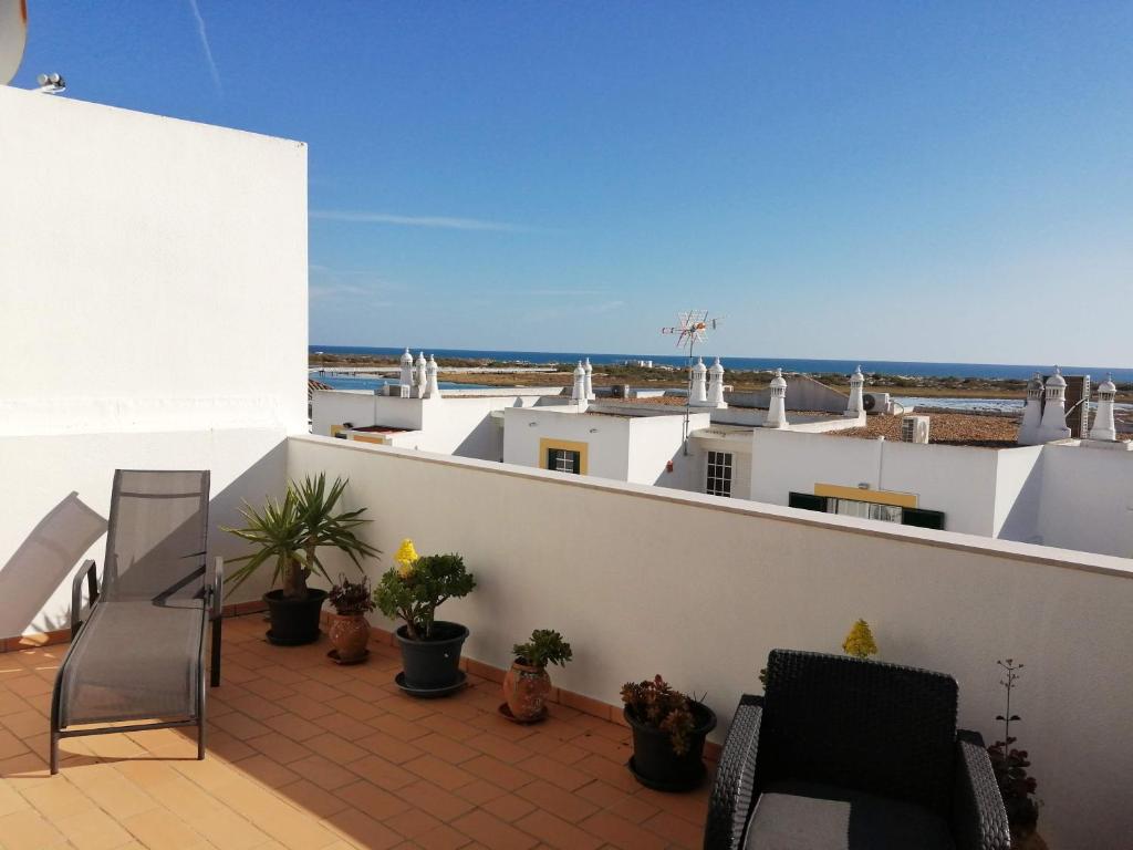 Un balcón con sillas y vistas al océano. en Apartamento Vista Mar, en Cabanas de Tavira