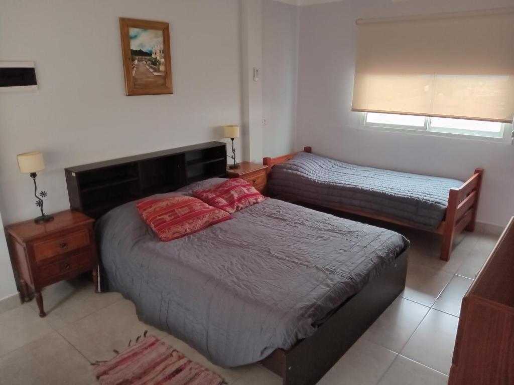 1 dormitorio con 2 camas individuales y ventana en Departamento Letty - con cochera en San Salvador de Jujuy