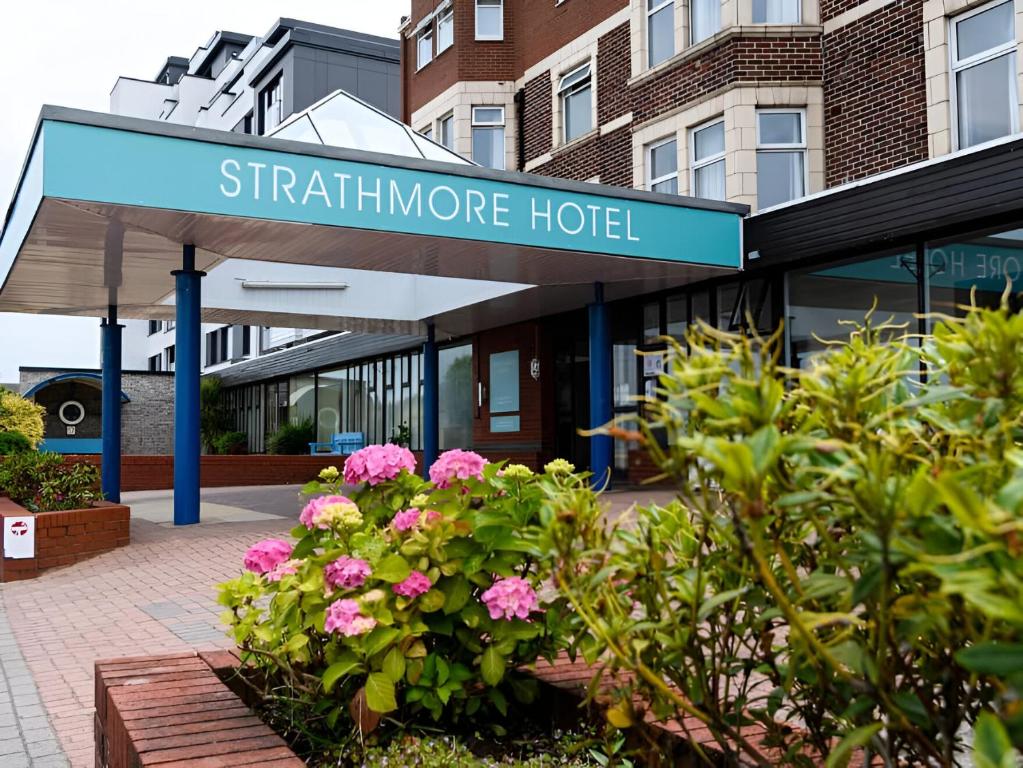 a sign for a stariline more hotel with pink flowers at The Strathmore Hotel in Morecambe