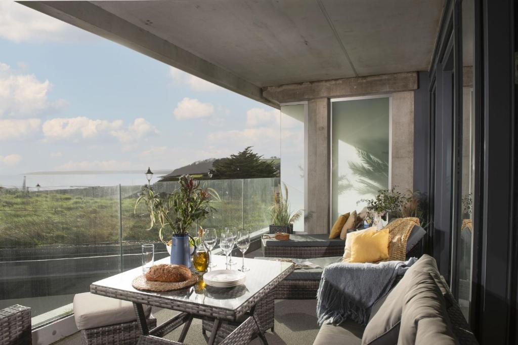 a living room with a table and a large window at Oceans Eleven - Sea view - Secure parking - Footsteps from beach in Falmouth