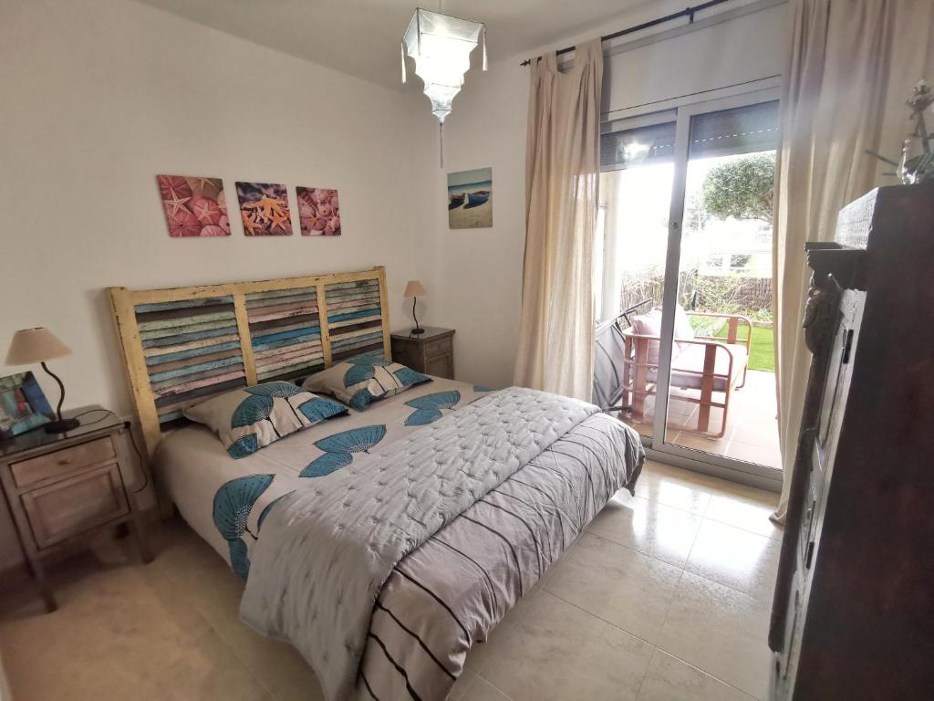 a bedroom with a bed and a sliding glass door at La Tarongina apartament amb piscina in Llança