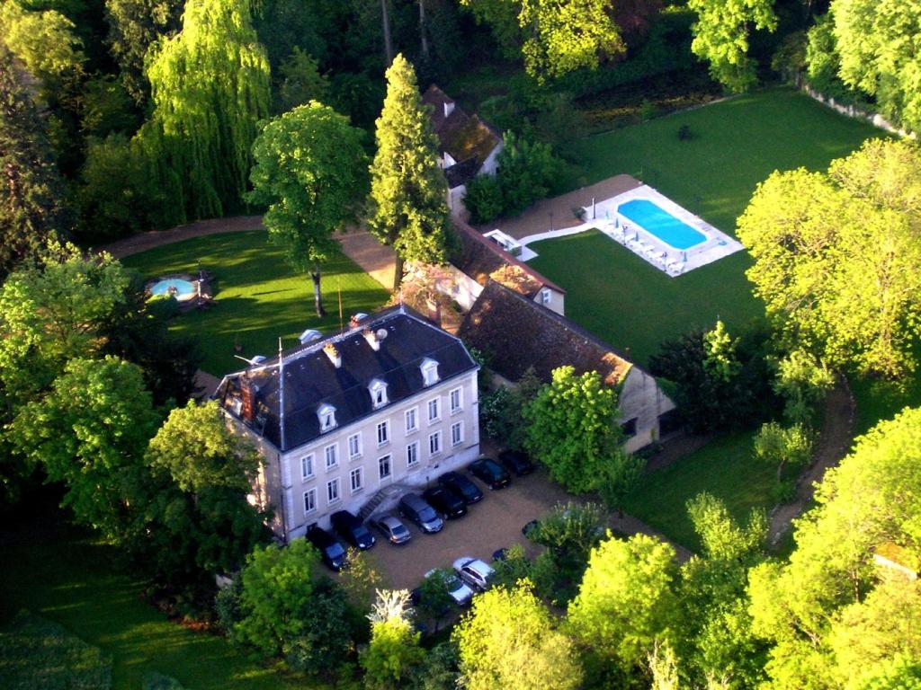 - une vue aérienne sur une grande maison avec une piscine dans l'établissement Château de Challanges, à Beaune