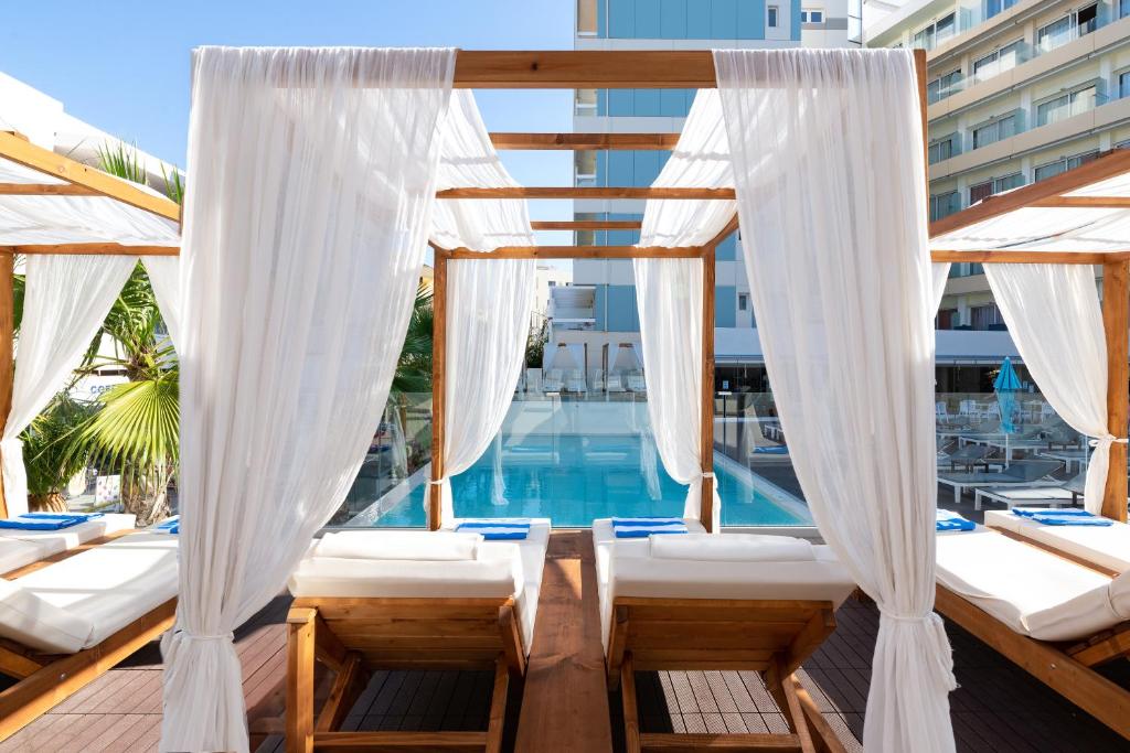 een balkon met bedden en een zwembad bij Arte hotel in Rhodos-stad