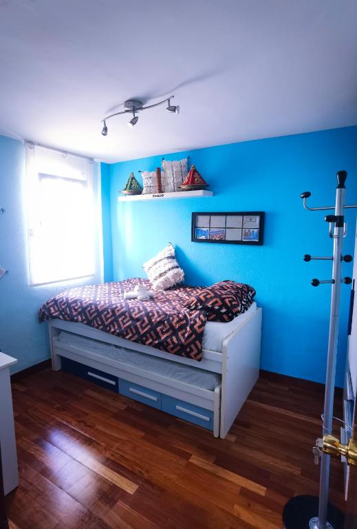 Ganga Room 2 في بلباو: غرفة نوم بجدران زرقاء وسرير