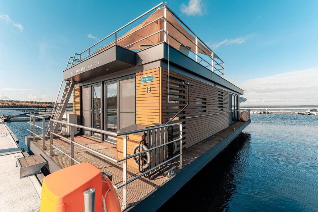 une maison sur un bateau sur l'eau dans l'établissement Hausboot Paradise, à Klitten