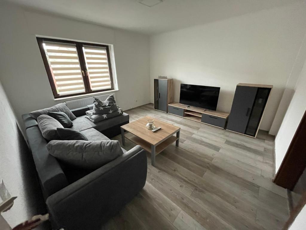 a living room with a couch and a tv at Apartment im Herzen von Alsdorf in Alsdorf