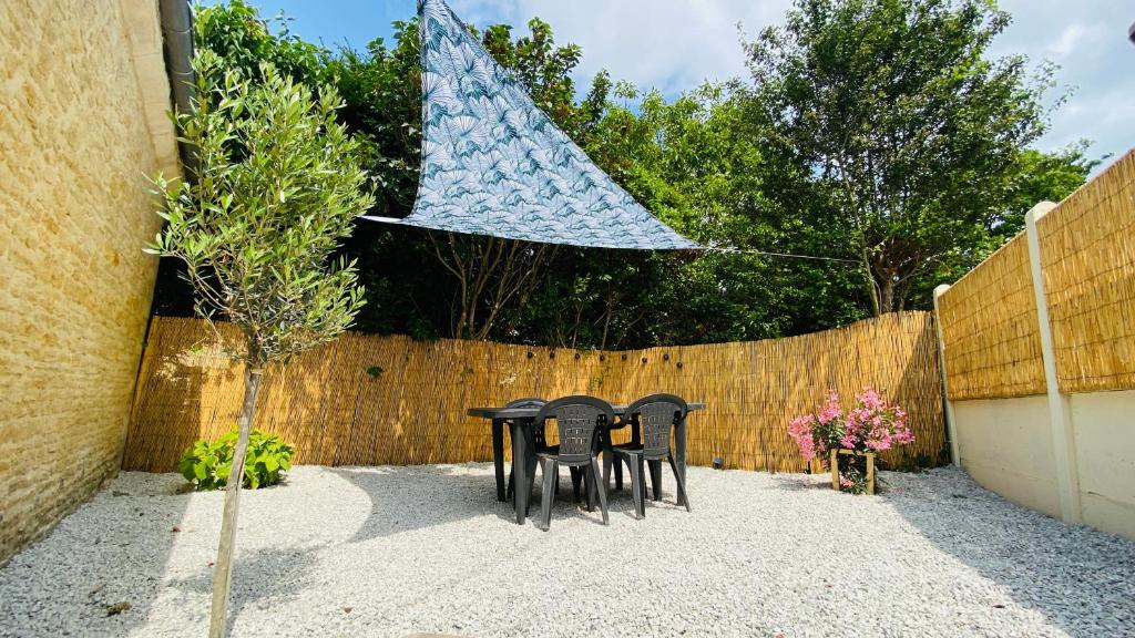 une paire de chaises noires devant une clôture dans l'établissement La casita, entre mer et campagne, à Douvres-la-Délivrande