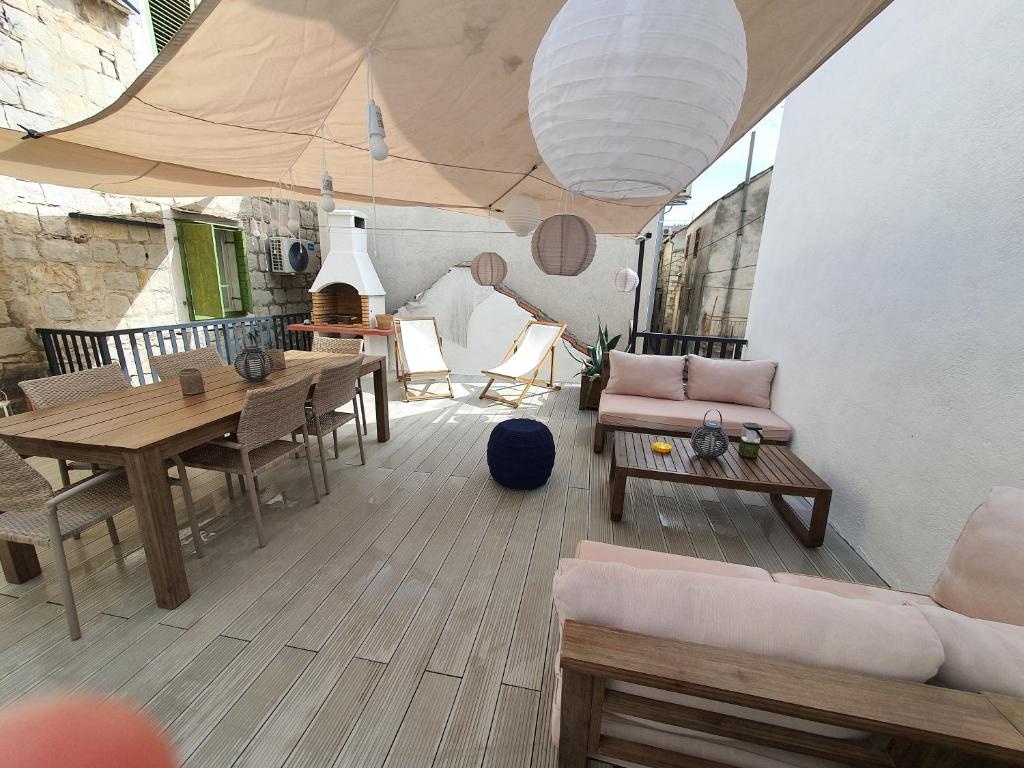 - un salon avec une table, des chaises et un canapé dans l'établissement Maison 2 chambres Olsavinia, à Kaštela