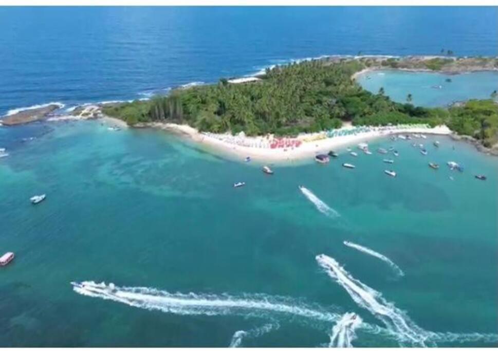 an island in the ocean with boats in the water at Casa de Praia Porto de Galinhas Toquinho in Ipojuca
